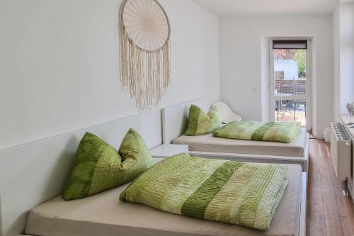 a room with three beds with green pillows at malerische Maisonettewohnung mit zwei Balkonen in Plauen