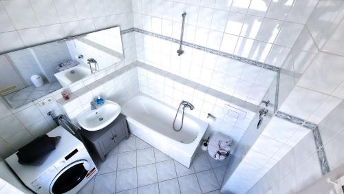 a white bathroom with a tub and a sink at malerische Maisonettewohnung mit zwei Balkonen in Plauen