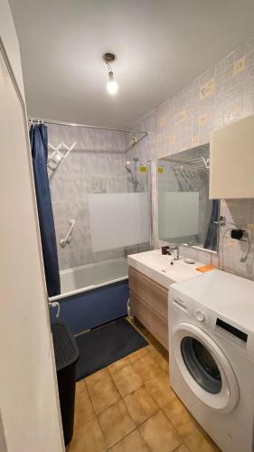 une salle de bain avec une machine à laver, un lavabo et une machine à laver dans l'établissement Belle place pour votre voyage à Paris-Ladefense, à Houilles