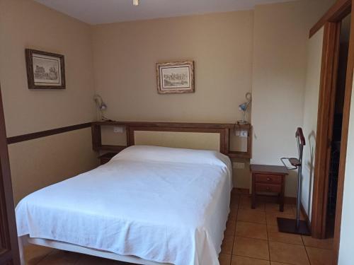 a bedroom with a white bed in a room at VIVIENDAS RURALES LAS CALDERAS in Santillana del Mar
