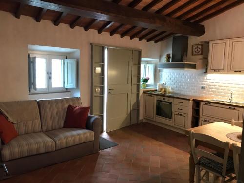 a kitchen with a couch and a table in a room at Appartamento Podere la Chiusa in Sesto Fiorentino