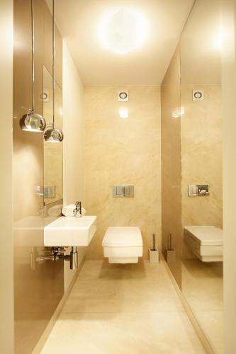 a bathroom with a sink and a toilet and a mirror at Malowesso Magic Apartment in Władysławowo