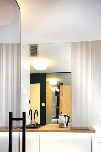 a kitchen with a sink and a mirror at Malowesso Magic Apartment in Władysławowo