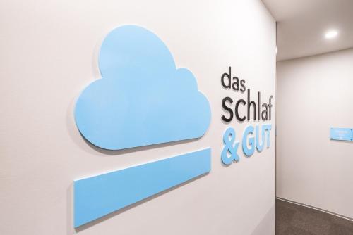 a blue cloud sign on a wall in a room at Das schlaf&GUT - Self Check-In in Leibnitz