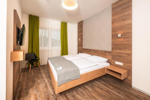 a bedroom with a bed and a green curtain at Das schlaf&GUT - Self Check-In in Leibnitz
