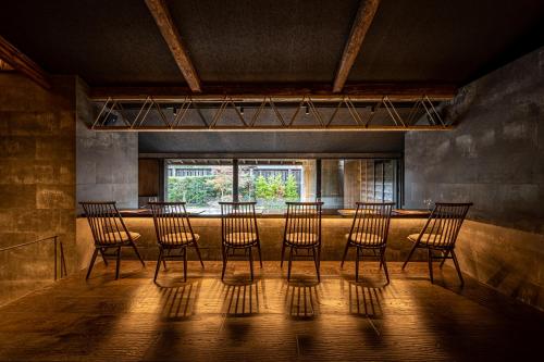 a group of chairs in a room with a window at BYAKU Narai in Shiojiri