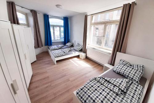 uma sala de estar com dois sofás e duas janelas em Work & Stay Apartment in Stolberg bei Aachen em Stolberg