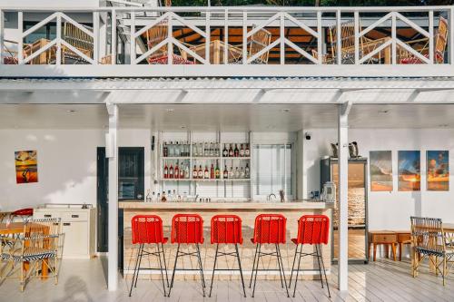 a bar with red bar stools in a kitchen at Casa De Lipe in Ko Lipe