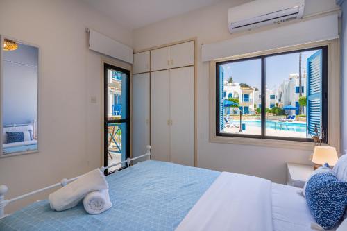 Sea Breeze 1-BR Apt in Pyla في بيلا: غرفة نوم مع سرير مع إطلالة على المسبح