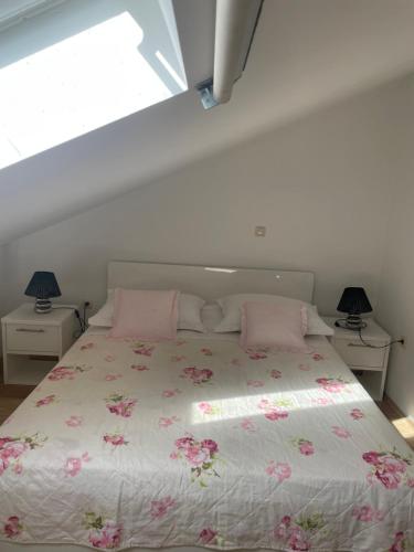 a bedroom with a bed with pink pillows and a window at Gallery for two, near the beach and the center of Jelsa in Jelsa
