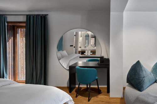 a bedroom with a mirror and a desk and a bed at Milka Boutique Hotel in Kranjska Gora