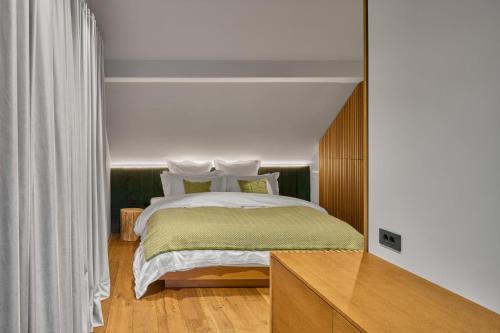 a bedroom with a bed with white pillows at Milka Boutique Hotel in Kranjska Gora