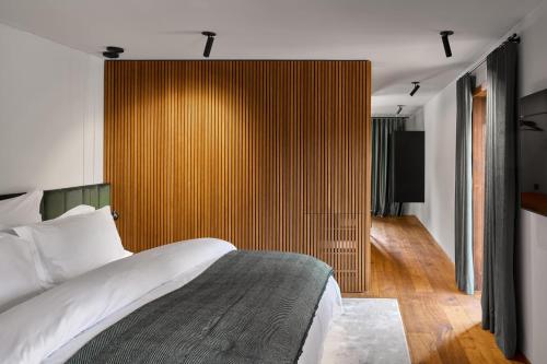a bedroom with a bed and a wooden wall at Milka Boutique Hotel in Kranjska Gora