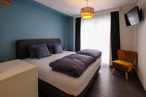 1 dormitorio con 1 cama, 1 silla y 1 ventana en Location Commodore Oostende, en Ostende