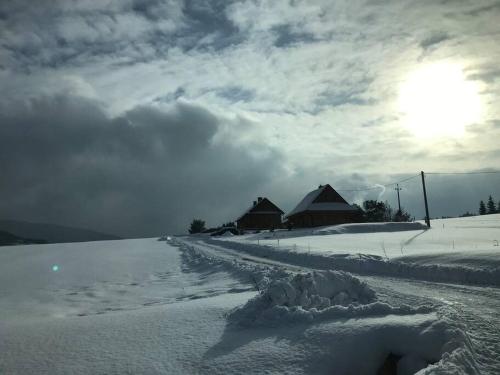 a road covered in snow with buildings in the background at Chatka_Kasina in Kasina Wielka