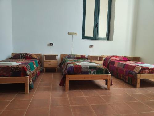 a room with two twin beds and a table at Beteyà Hostel Don Bosco in Catania