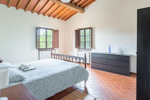 a bedroom with a bed and a kitchen with windows at La Casina di Elisa in Montecarlo