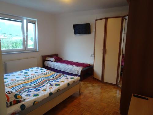 a small bedroom with two beds and a window at Apartma Dana-Brinjtesa in Jesenice