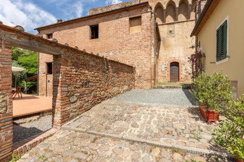 a brick building with a stone walkway next to it at La Casina di Elisa in Montecarlo