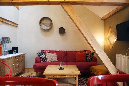 a living room with a red couch and a table at Thomashof Klein-Mutz in Zehdenick