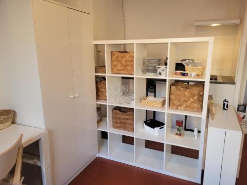 une cuisine avec une armoire blanche et des étagères dans l'établissement Aix-en-Provence Superbe studio centre historique, à Aix-en-Provence