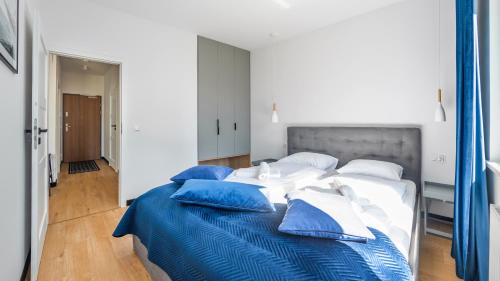 a bedroom with a large bed with blue and white pillows at Nexo, Sun & Snow in Puck