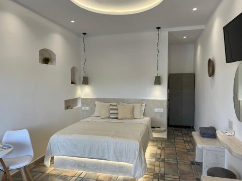 a bedroom with a bed and a table and a tv at Arapiou Apartments in Perivolos