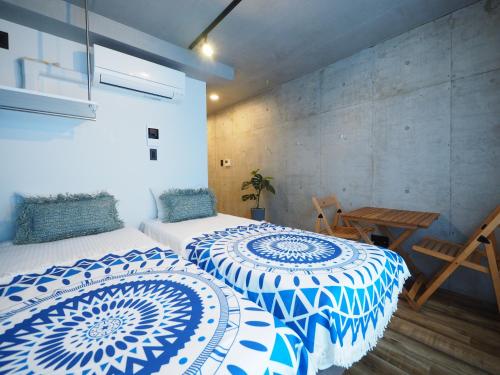 two beds with blue and white covers in a room at Luana Shibuya in Tokyo
