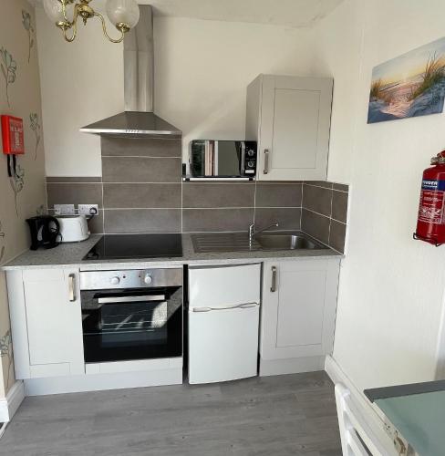 a small kitchen with a sink and a stove at 1 Bedroom Holiday Apartment Skegness - Flat 14 in Skegness