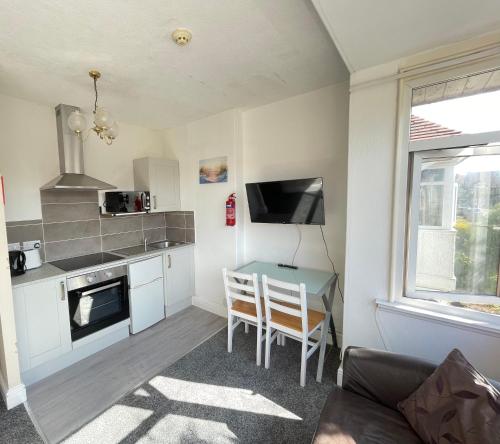a kitchen with a table and a kitchen with a stove at 1 Bedroom Holiday Apartment Skegness - Flat 14 in Skegness