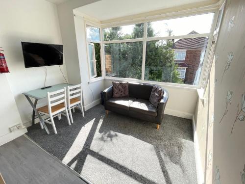 a living room with a couch and a table and a window at 1 Bedroom Holiday Apartment Skegness - Flat 14 in Skegness