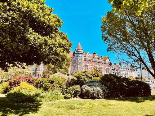 a large building with a clock tower in a park at Southsea Retreat in Southsea