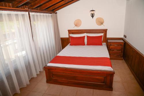 a bedroom with a wooden bed with red pillows at Enso Inn in Fethiye