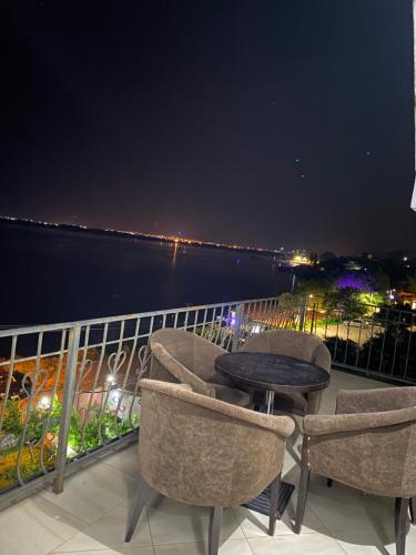 a balcony with chairs and a table at night at LakeFront House in Shirokë