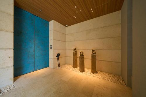a room with pillars in a building with a blue wall at Hotel Resol Trinity Naha in Naha