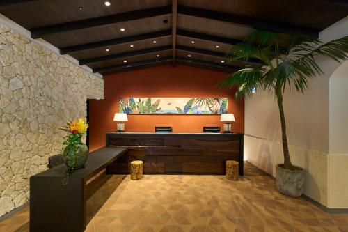 a room with a table and a palm tree in it at Hotel Resol Trinity Naha in Naha