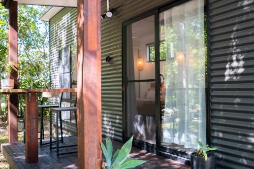 a screened in porch of a house with a sliding glass door at Airlie Beach Eco Cabins - Adults Only in Airlie Beach