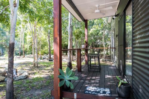 a screened porch of a house with a fan at Airlie Beach Eco Cabins - Adults Only in Airlie Beach