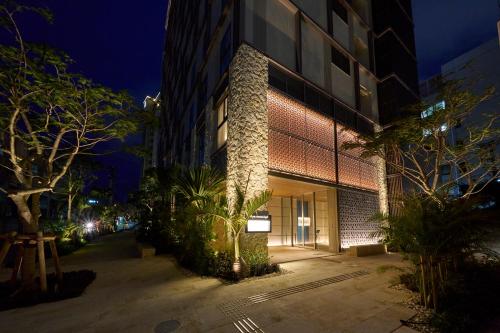 a building on a street at night at Hotel Resol Trinity Naha in Naha