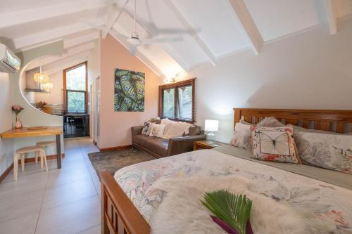 ein Schlafzimmer mit einem Bett und ein Wohnzimmer in der Unterkunft Airlie Beach Eco Cabins - Adults Only in Airlie Beach