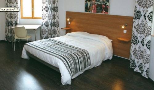 a bedroom with a bed with a wooden head board at La Tour Des Lys in Maubeuge