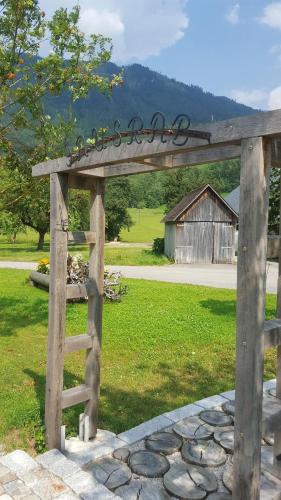 a wooden arch with a sign in a field at Gausrab in Hinterstoder