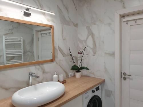 a white bathroom with a sink and a mirror at Max Studio in Sancraiu de Mures