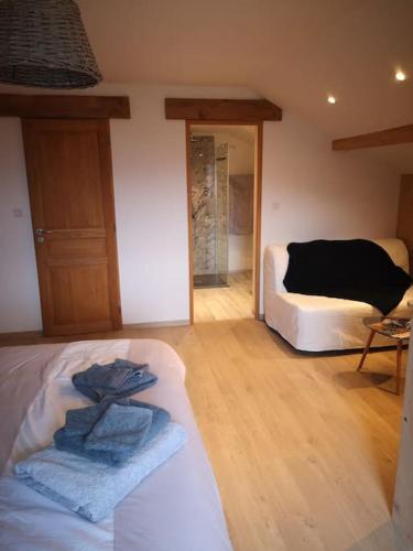 a bedroom with a bed and a room with a couch at chambre d'hôtes nos racines (chez Muriel et Philippe) in Saulxures-sur-Moselotte