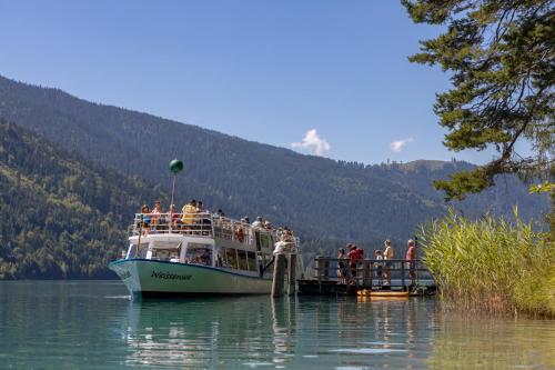 a group of people on a boat on a lake at die weisse Wand in Weissensee