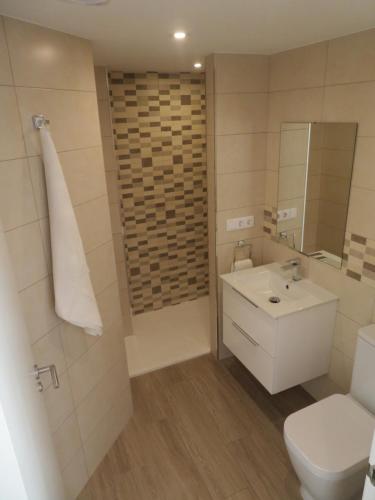 uma casa de banho com um WC, um lavatório e um espelho. em Apartamento Na Beira Do Mar em O Pindo