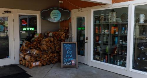 a store with a sign in front of a pile of wood at Ocean Adventure in Ocean Shores