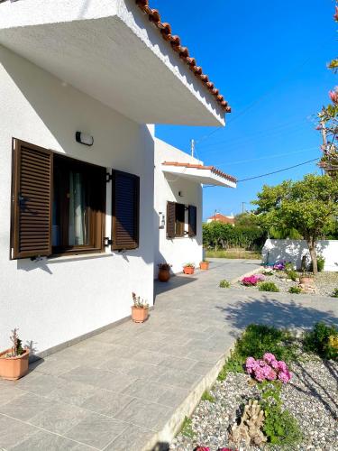 a white house with a window and some flowers at Casa di Vati in Vátion