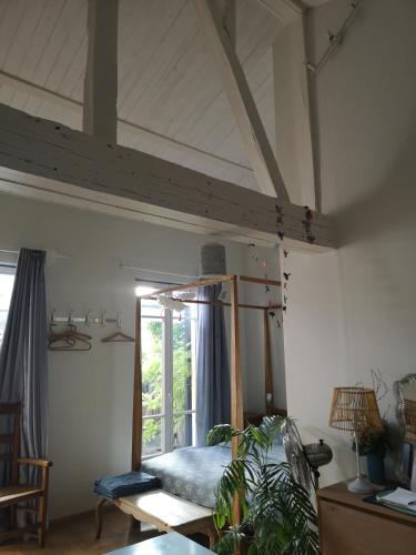 une chambre avec un lit et une fenêtre dans une pièce dans l'établissement Chambre en ville dans un esprit campagne, à Troyes