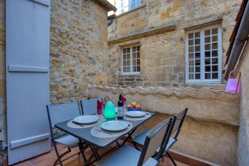 une table et des chaises sur le balcon d'un bâtiment dans l'établissement Chez Alice appartement en plein centre ville, à Sarlat-la-Canéda